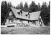 Photograph of the Crater Lake Superintendent's Residence, showing walls built of large stones and wooden gables.