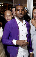 A man dressed in a white shirt and purple jacket.