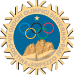 A stylized snowflake with the Olympic rings, a star and mountains. Surrounding the perimeter of the snow flake are the words, "VII Giochi Olimpici Dinverno, Cortina d'Ampezzo 1956"