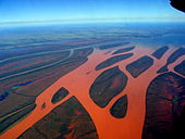 Aerial photograph of a forked river that has turned red due to red soil runoff
