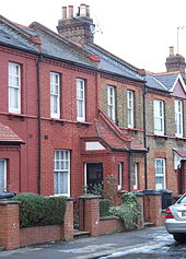 Small two storey houses, with the front doors set in small outbuildings to open perpendicular to the front of the house