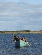 Two men rowing in a canoe.