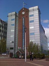 Six storey office building with facing brick, glass and silver cladding with clock feature.
