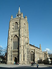 Tall ornately carved stone church with a large square tower
