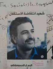  A poster displaying the face of Samir Kassir and containing Arabic text, the DLM logo, and some sharpie scribbles