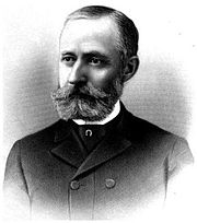 chest high portrait in a suit with mustache and beard