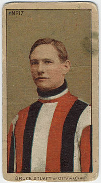 Brown-haired man in jersey of vertical red, black and white stripes