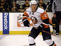 A Caucasian male wearing an white, blue and orange jersey. Streit is skating as a member of the New York Islanders.
