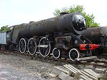 A front-and-side view of a Merchant Navy locomotive in near-scrapyard condition before restoration starts. Many important components are missing, such as the valve gear, the smoke deflectors and the tender.