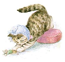 A kitten captures a mouse by the tail
