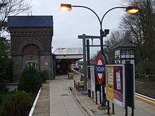 Railway station platform with a garden on one side and railway tracks on the other