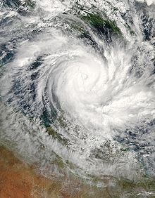 Satellite view of a large, well-developed tropical cyclone near northern Queensland. A pronounced, yet cloud-filled, eye and curved rainbands mark the characteristics of a mature storm.