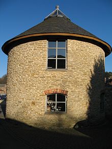 Circular stone building with slate roof.