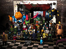 A compute image of approximately 40 characters, most skeletal figures with a few large, cartoonish characters, arranged on a series of steps, posing for the photograph; one figure is of a human face imposed onto the character.
