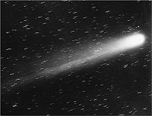 Black and white photograph of the comet, its nucleus brilliant white, and its tail very prominent, moving up and to the right