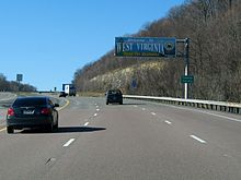 A sign above the highway reads "Welcome to West Virginia - Open For Business." An adjacent sign reads "Preston County."