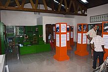 Several people stroll around a room full of exhibits.
