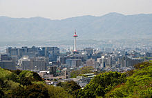 Picture of a skyline of a modern city with mountains in the background.