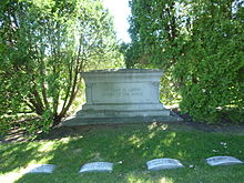 Large monument between two trees, inscribed "Charles M. Loring/Father of the Parks". Loring's grave is center left of four visible.