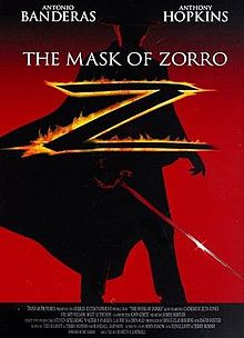 A dimly-lit figure sporting a rapier, a black costume with a flowing Spanish cape, a flat-brimmed black gaucho hat, and a black cowl sackcloth mask that covers the top of the head from eye level stands with the film's title: THE MASK OF ZORRO in white font. He is silhouetted against a red hue fading to black at the top with the star billing of ANTONIO BANDERAS and ANTHONY HOPKINS.