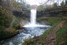 Minnehaha Falls surrounded by dirt and green foliage probably in early spring
