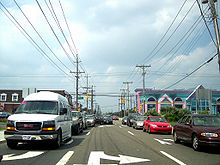 A congested one-way road facing traffic. The road is lined by power lines and businesses.