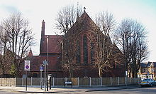 A red brick church, with very tall thin windows and no spire or tower