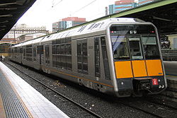 An Outer Suburban Tangara in original livery with orange squares below the driver's cab.