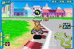 An orange bipedal dinosaur rides a small go-kart around the corner of a paved race track. Two other racers are visible around him. Futuristic buildings appear in the daytime background. Stylized features such as time remaining and a small map of the course adorn the edges of the screen.