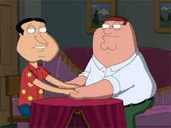 A cartoon drawing of two men, one fatter than the other wearing a white shirt and glasses, and the other with dark hair and a red and yellow shirt, holding hands across a table, with the lights dimmed, as they glare into each other's eyes.