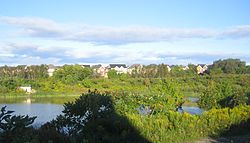 Mantle Site – looking west from Byers Pond Way, Whitchurch-Stouffville over storm water pond towards Stouffville Creek and James Ratcliff Ave.: site of massive 16th century Wendat (Huron) ancestral village