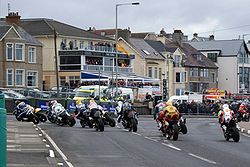 Several motorcycle racers on the approach to a left hand corner.