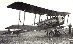 Manned single-engined military biplane parked on airfield