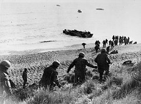 Men running down cliff towards a waiting boat on the shore line