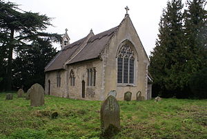 A simple stone church seen from the southeast, showing the chancel and the nave with a bellcote at the far end