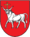 A coat of arms depicting a white bull with an angry expression and a golden cross protruding from its head all on a red background