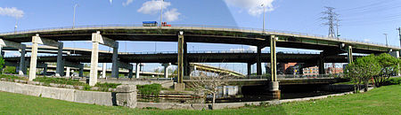 Two elevated roadways with two connecting ramps above a river.