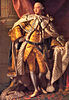 Man dressed in elaborate gold, white, and black coronation robes made of satin and fur.
